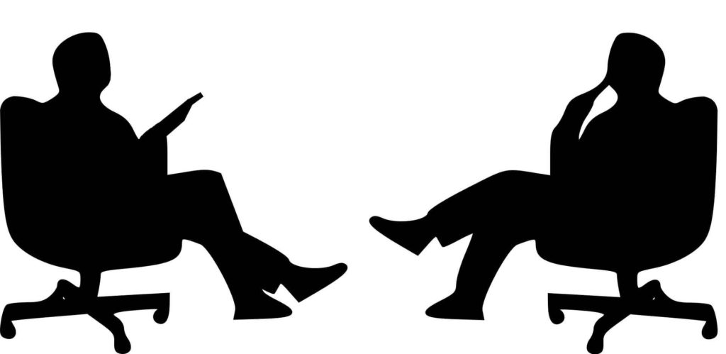 Two people talking while sitting in chairs